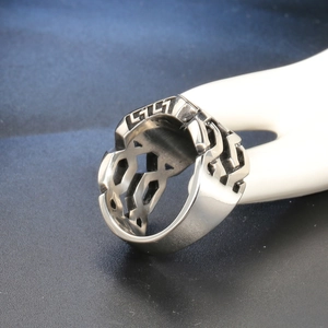 Close-up of punk style stainless steel ring with hollow geometric patterns and G-shape engraving