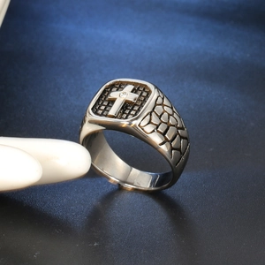 Macro shot of men's stainless steel cross ring with black grid and small diamond