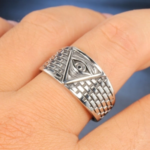 Macro shot of stainless steel Freemasonry Eye of Providence ring with brick texture