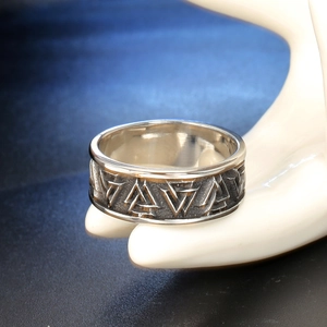Vintage stainless steel Valknut ring with Nordic knot relief on a display stand