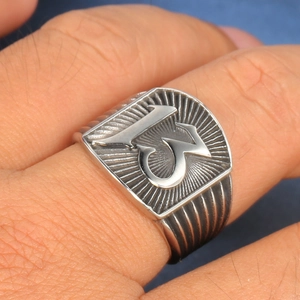 Macro detail of men's stainless steel punk ring featuring a bold number 13 on shield