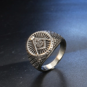 Macro view of Freemasonry G symbol on vintage stainless steel ring with relief details