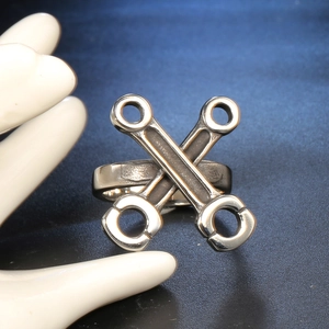 Detail of creative silver wrench ring with cross design and polished metallic finish