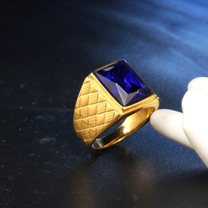 Dettaglio macro di anello vintage dorato con grande gemma blu rettangolare e incisioni