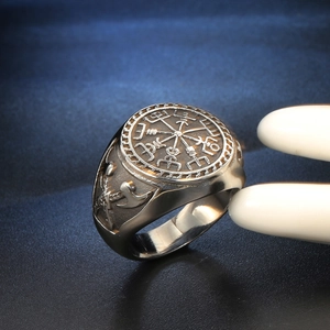 Vintage stainless steel Viking compass ring with double axe relief on blue background