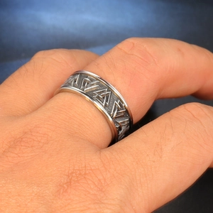 Close-up of vintage stainless steel ring with embossed Valknut Nordic symbol
