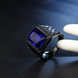 Dettaglio macro di pietra blu su anello in acciaio nero con trama a rombi incisi