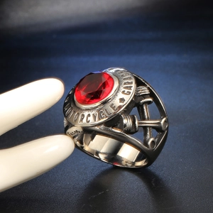 Vintage steel motorcycle ring featuring a faceted red ruby stone and industrial engraving