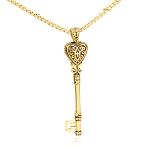 Pendentif clé en forme de cœur doré avec filigrane vintage sur une chaîne à mailles