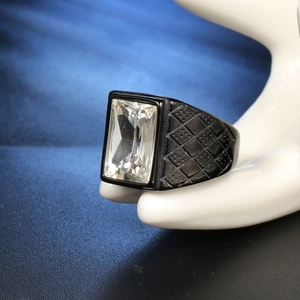 Dettaglio dell'anello placcato nero con pietra rettangolare e fascia testurizzata in mostra
