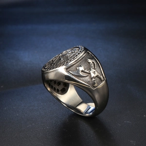 Detail of Viking totem ring showing cross axes relief and oxidized steel texture