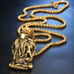 Collier avec pendentif Ganesha en acier inoxydable doré antique sur un fond noir mat