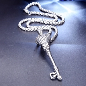 Détail macro du pendentif clé vintage argenté avec sculpture de cœur en filigrane
