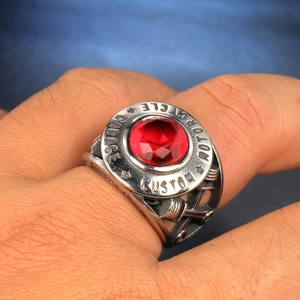Macro shot of stainless steel motorcycle ring featuring a ruby red center stone and engraving