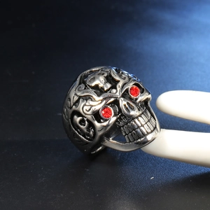 Detail of gothic punk skull ring with red rhinestone eyes and vintage silver finish