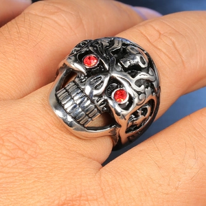 Detailed view of punk skull ring in vintage silver with red rhinestone eyes and engravings