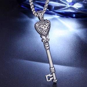 Détail d'un pendentif clé en forme de cœur vintage avec gravure filigrane en argent vieilli
