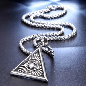 Macro detail of punk style Eye of Providence pendant with heavy stainless steel box chain