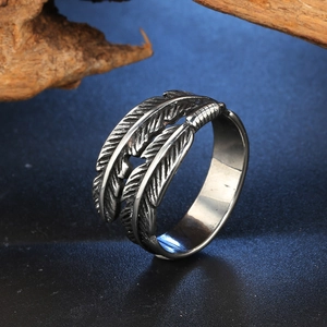 Detailed view of retro feather ring with intricate metallic textures and open design