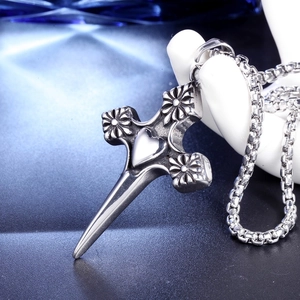 Macro d'un pendentif croix argenté vintage avec cœur sur un support texturé