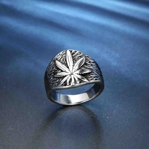 Macro detail of silver maple leaf carving on vintage stainless steel men's ring