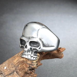 Vue détaillée d'une bague tête de mort punk en acier sur une texture d'écorce de bois