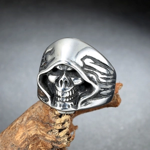Gothic skull ring for men in silver steel, hooded reaper design on rustic wood background