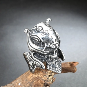 Gothic skull ring in vintage stainless steel with embossed relief on a wooden branch