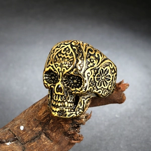 Detailed relief of skull ring with Mexican Day of the Dead floral patterns on rustic wood