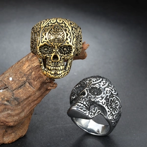 Gothic punk skull rings in gold and silver finish on vintage wood stand