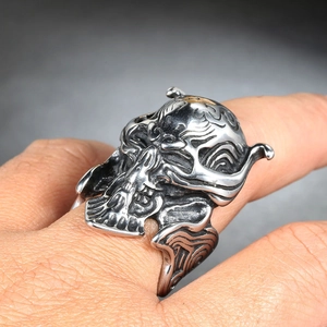 Detailed view of heavy vintage skull ring with intricate floral carvings on metal