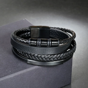 Detail of multi-layer braided leather bracelet with black magnetic clasp and metal accents