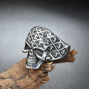 Macro shot of punk style skull ring with vintage silver relief on textured wood branch