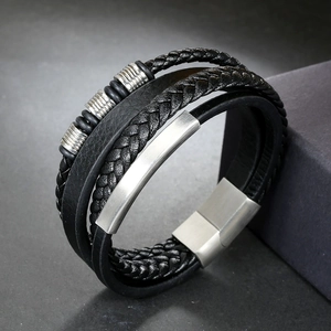 Detail of multi-layer braided leather bracelet with silver textured metal beads and magnetic clasp