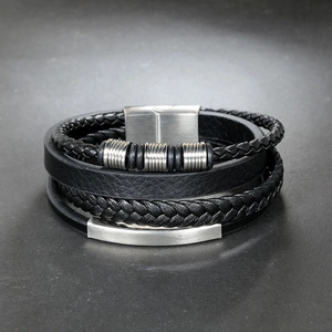Detail of multi-layer braided leather men's bracelet with textured metal rings and clasp