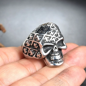 Macro shot of gothic skull ring featuring engraved fleur-de-lis patterns and vintage finish