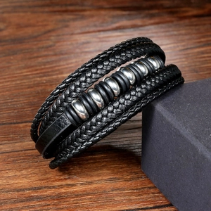 Détail d'un bracelet multicouche en cuir noir tressé avec perles en métal argenté