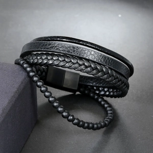 Detailed macro view of multi-layer black braided leather cord bracelet and matte beads