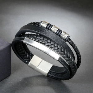 Detailed close-up of multi-layer black braided leather bracelet with magnetic buckle