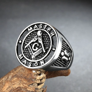 Macro detail of Master Mason signet ring with engraved compass logo on wood texture
