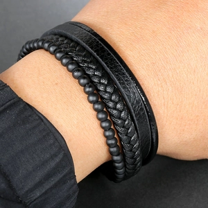 Macro detail of multi-layer men's leather bracelet with matte beads and magnet clasp
