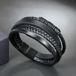 Detail of multi-layer black braided leather bracelet with magnetic metal clasp