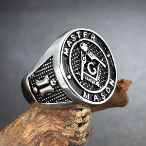 Detailed view of silver and black stainless steel Master Mason ring on wood