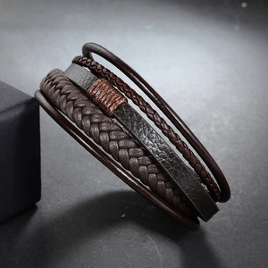Detail of multi-layer hand-woven leather bracelet featuring brown thread decorative knots