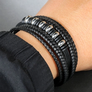Détail d'un bracelet multicouche en cuir tressé noir avec perles en argent poli
