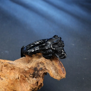 Gros plan d'une bague tête de mort noire gothique avec texture d'os sur bois