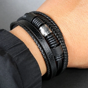 Detail of multi-layer braided black leather bracelet with stainless steel metal accents