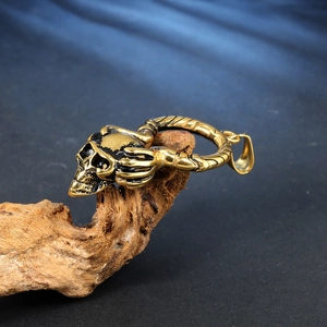 Collier avec pendentif crâne doré vintage et détail de griffe sur branche de bois