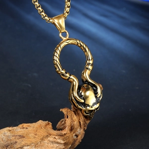 Collier avec pendentif crâne doré vintage et cornes en spirale sur support bois