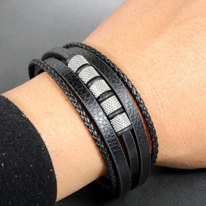 Close-up of multilayer black leather bracelet with textured silver metal cylinder beads